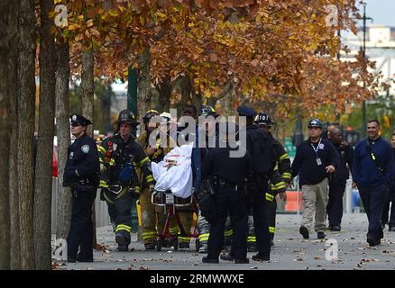 (141112) -- NEW YORK, 12 novembre 2014 -- les pompiers transportent les lave-vitres jusqu'à une ambulance après des travaux de sauvetage dans le One World Trade Center à New York, aux États-Unis, le 12 novembre 2014. Deux laveurs de fenêtres ont été piégés pendant une heure mercredi sur un échafaudage suspendu au-dessus de la face du One World Trade Center, le plus haut bâtiment de l'hémisphère occidental. Les pompiers ont coupé à travers une fenêtre du 69e étage et les ont doucement tirés à l'intérieur pour les mettre en sécurité.) US-NEW YORK-ONE WORLD TRADE CENTER-ACCIDENT-LAVE-VITRE WangxLei PUBLICATIONxNOTxINxCHN New York nov 12 2014 les pompiers portent le lave-vitre Banque D'Images