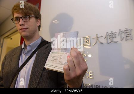 (141112) -- WASHINGTON D.C., 12 novembre 2014 -- Edmund Thomas Downie montre son visa à la presse après être devenu le premier citoyen américain à se voir délivrer un visa de dix ans au Département des visas de l'ambassade de Chine aux États-Unis à Washington D.C., le 12 novembre 2014. La Chine a délivré mercredi le tout premier groupe de visas avec une validité de dix ans aux citoyens américains, mettant en œuvre un nouvel accord qui devrait stimuler les échanges entre les deux pays. US-WASHINGTON D.C.-CHINA-TEN-YEAR-VISA-ÉMIS YinxBogu PUBLICATIONxNOTxINxCHN Washington D C novembre 12 2014 Edmund Thomas Downie montre le sien Banque D'Images