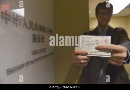 (141112) -- WASHINGTON D.C., 12 novembre 2014 -- Edmund Thomas Downie montre son visa à la presse après être devenu le premier citoyen américain à se voir délivrer un visa de dix ans au Département des visas de l'ambassade de Chine aux États-Unis à Washington D.C., le 12 novembre 2014. La Chine a délivré mercredi le tout premier groupe de visas avec une validité de dix ans aux citoyens américains, mettant en œuvre un nouvel accord qui devrait stimuler les échanges entre les deux pays. US-WASHINGTON D.C.-CHINA-TEN-YEAR-VISA-ÉMIS YinxBogu PUBLICATIONxNOTxINxCHN Washington D C novembre 12 2014 Edmund Thomas Downie montre le sien Banque D'Images