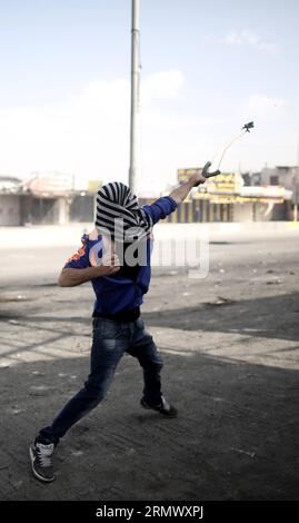 (141114) -- RAMALLAH, 14 novembre 2014 -- Un manifestant palestinien lance des pierres sur des soldats israéliens lors d'affrontements au poste de contrôle de Qalandiya près de la ville de Ramallah en Cisjordanie le 14 novembre 2014. Des affrontements ont éclaté vendredi entre manifestants palestiniens et soldats israéliens dans plusieurs villes de Cisjordanie contre les récentes mesures israéliennes à Jérusalem. (Dzl) MIDEAST-RAMALLAH-AFFRONTEMENTS FadixArouri PUBLICATIONxNOTxINxCHN Ramallah nov 14 2014 un hurle PALESTINIEN des pierres contre des soldats israéliens lors d’affrontements AU poste de contrôle de Qalandiya près de la ville de Ramallah en CISJORDANIE LE 14 2014 novembre des affrontements ont éclaté FR Banque D'Images