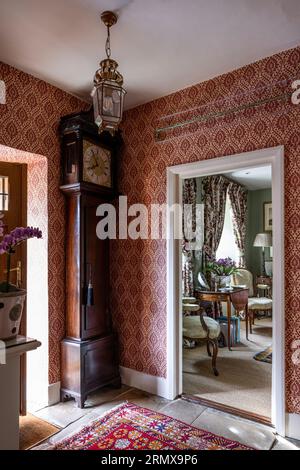 Tissu ancien grand-père et papier peint en 'Furnvilll' avec tapis d'Alep dans le hall d'entrée géorgien du 18e siècle, Northamptonshire, Royaume-Uni Banque D'Images