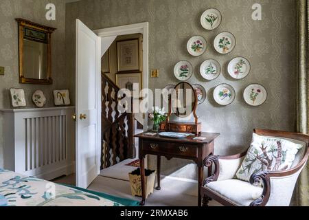 Assiettes décoratives sur papier peint en vert 'Ashdown Natural' dans une chambre géorgienne du 18e siècle, Northamptonshire, Royaume-Uni Banque D'Images