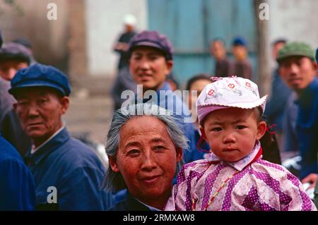 China. Qinghai. Xining. Local woman & child in crowded street. 1980's. Stock Photo