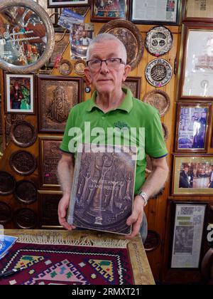 Fier propriétaire d'un Coppersmith Shop rue Kazandžiluk montre un livre avec des photos de la boutique. Ville de Sarajevo, 30 août 2023 Banque D'Images