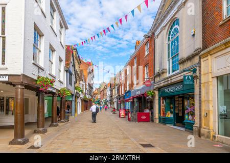 Boutiques, cafés-terrasses et pubs bordent le principal quartier commerçant de High Street dans la ville historique médiévale de Winchester, Angleterre, Royaume-Uni. Banque D'Images