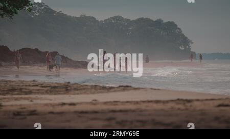 Groupe de personnes inconnues appréciant la vie de plage et le plaisir sur Playa Cocles près de Puerto Viejo au Costa Rica sur evenyng brumeux à la plage de jungle des caraïbes Banque D'Images