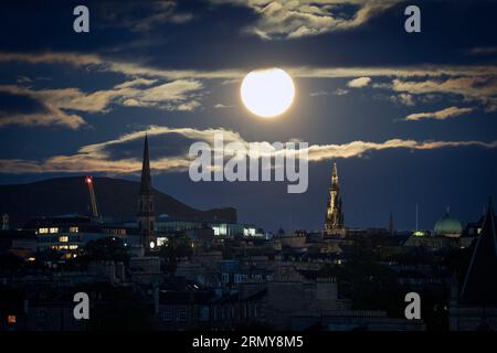 La lune super bleue se lève au-dessus d'Edimbourg. La lune bleue fait référence à la deuxième pleine lune d'un mois calendaire, qui se produit environ une fois tous les deux ou trois ans. Celui-ci est aussi une superlune - quand le satellite naturel de la Terre apparaîtra environ 14% plus grand et 30% plus lumineux dans le ciel quand il atteindra son point le plus proche de la Terre. Date de la photo : mercredi 30 août 2023. Banque D'Images