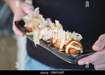 Photo de la personne non reconnue servant une délicieuse assiette de sushis avec sauces spéciales. Banque D'Images