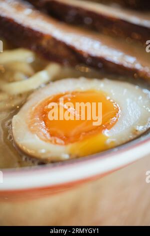 Photo de la délicieuse soupe de ramen aux œufs durs et à la viande dans le restaurant japonais. Banque D'Images