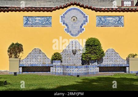 Bancs décorés de tuiles et fontaine sur jardin au Brésil Banque D'Images