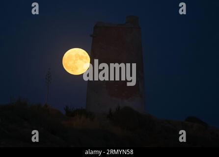 Malaga, Espagne. 30 août 2023. La superlune bleue, la deuxième superlune d'août, se lève sur le ciel à côté d'une tour de pierre (connue sous le nom de tour 'Las Palomas') sur la plage 'la Araña'. La superlune bleue se déroule comme l'un des événements astronomiques les plus frappants du mois. Lorsque la pleine lune a lieu, elle apparaît plus grande et plus lumineuse que la normale. (Photo Jesus Merida/SOPA Images/Sipa USA) crédit : SIPA USA/Alamy Live News Banque D'Images