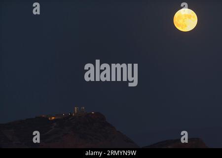 Cap Sounion, Grèce. 30 août 2023. Une pleine lune se lève au-dessus du temple de Poséidon au cap Sounion, près d’Athènes, Grèce, le 30 août 2023. Crédit : Marios Lolos/Xinhua/Alamy Live News Banque D'Images