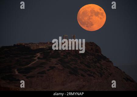 Cap Sounion, Grèce. 30 août 2023. Une pleine lune se lève au-dessus du temple de Poséidon au cap Sounion, près d’Athènes, Grèce, le 30 août 2023. Crédit : Marios Lolos/Xinhua/Alamy Live News Banque D'Images