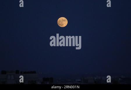 Rafah, Gaza. 02 avril 2023. Une "Lune bleue" est vue se lever dans le ciel de la bande de Gaza au-dessus de Rafah dans le Sud de la bande de Gaza le mercredi 30 août 2023. Une « Lune bleue » est la deuxième pleine lune en un mois. Photo par Ismael Mohamad/UPI crédit : UPI/Alamy Live News Banque D'Images