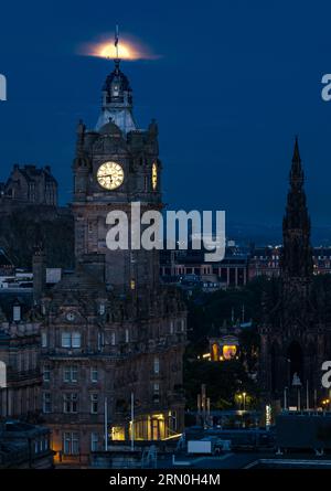 Édimbourg, Écosse, Royaume-Uni, 31 août. UK Météo : pleine superlune bleue. La pleine superlune se déroule sur l'emblématique horizon de la ville avec la flèche du monument Scott et la tour de l'horloge Balmoral montrant une heure de 6h vue de Calton Hill. Il n'y aura pas d'autre superlune bleue avant 2037. Crédit : Sally Anderson/Alamy Live News Banque D'Images