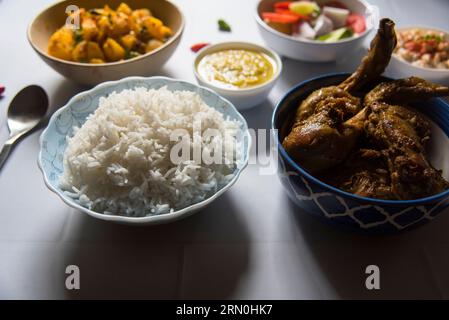 Repas indien riz vapeur et curry de poulet servis avec condiments. Banque D'Images