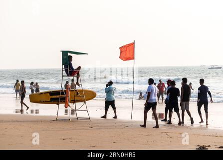 Calangute, Goa, Inde - janvier 2023 : un sauveteur veille sur une foule de touristes à la plage. Banque D'Images