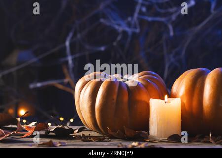 Citrouilles, bougies et décorations en toile d'araignée avec espace de copie sur fond noir Banque D'Images