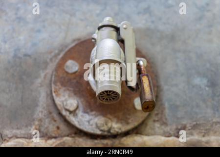 Un robinet d'eau sur la citerne verrouillé par un cadenas, en gros plan Banque D'Images