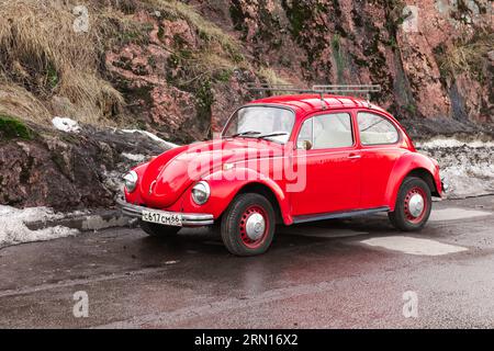 Vyborg, Russie - 15 avril 2023 : Vintage rouge Volkswagen Kafer se tient sur une route par temps nuageux Banque D'Images