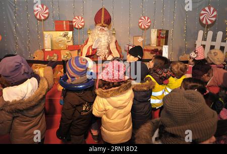 (141205) -- BRUXELLES, 5 décembre 2014 -- des enfants attendent pour parler avec Saint Nicolas lors du festival Saint Nicolas à Bruxelles, Belgique, le 5 décembre 2014. Le festival Saint Nicolas arrive traditionnellement aux pays-Bas et en Belgique chaque année à la mi-novembre ou décembre. Défilant dans les rues sur son cheval, avec son assistant serviable Black Pete, il est traditionnellement accueilli par les enfants acclamant et chantant des chants traditionnels de Saint Nicolas.) BELGIQUE-BRUXELLES-SAINT NICOLAS FESTIVAL YexPingfan PUBLICATIONxNOTxINxCHN Bruxelles DEC 5 2014 les enfants attendent pour parler avec Saint Nicolas pendant le Saint Nico Banque D'Images