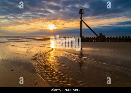 Une image de paysage du lever du soleil sur la plage de Mundesley, Norfolk Nord, Royaume-Uni Banque D'Images