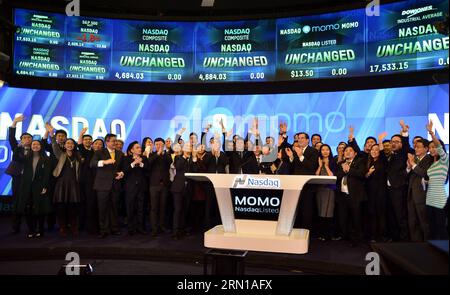 (141211) -- NEW YORK, le 11 décembre 2014 -- Yan Tang (C, front), fondateur et directeur général de la plateforme de réseaux sociaux mobiles Momo Inc. En Chine, assiste à la cérémonie de sonnerie de la cloche d'ouverture au NASDAQ à New York, aux États-Unis, le 11 décembre 2014. La plate-forme chinoise de réseaux sociaux mobiles Momo Inc. A coté ses actions jeudi sur le marché mondial SELECT du NASDAQ. La société a annoncé que son offre publique initiale de 16 millions d'actions dépositaires américaines (ADS) était au prix de 13,5 dollars américains par ADS pour une taille totale d'offre de 216 millions de dollars. US-NEW YORK-MOMO-NASDAQ-IP Banque D'Images