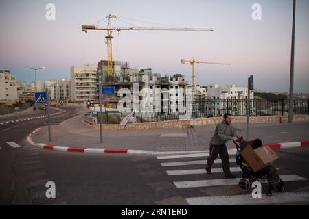 POLITIK Israel genehmigt Siedlungsbau BEI Ramot und Har Homa (141225) -- JÉRUSALEM, 24 décembre 2014 -- une photo prise le 27 octobre 2013 montre un homme pousse une poussette de bébé alors qu'il marche à côté d'un chantier de construction de logements dans la colonie israélienne de Har Homa, Jérusalem-est. Un comité municipal de Jérusalem a approuvé le 24 décembre 2014 la construction de près de 400 nouvelles unités de logement dans des colonies juives sur des terres annexées par Israël pendant la guerre du Moyen-Orient de 1967. Le Comité de planification et de construction de Jérusalem a approuvé mercredi 380 maisons au total, dont 307 seront situées dans le quartier nord-est Banque D'Images