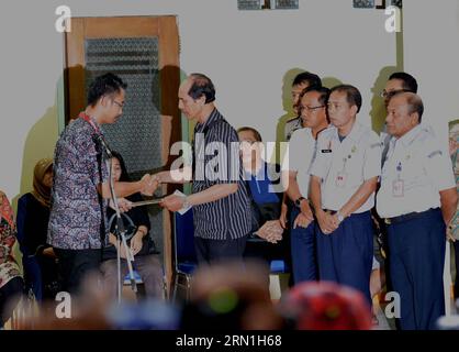 AKTUELLES ZEITGESCHEHEN Absturz von AirAsia-Flug QZ8501 - Angehörige trauern (150101) -- SURABAYA, le 1 janvier 2015 -- Un représentant d'AirAisa remet des documents à un membre de la famille d'un passager d'AirAsia QZ8501 lors de la cérémonie de remise à Surabaya, le 1 janvier 2015. Les experts identifiant les victimes de l'avion AirAsia qui a coulé dans les eaux indonésiennes ont annoncé jeudi le premier résultat de leurs travaux pour identifier deux corps, disant qu'ils allaient remettre l'un d'eux à sa famille bientôt. Chef de l'identification des victimes de catastrophe (DVI) nommé seulement Budiono a déclaré que l'un des deux corps a été avec succès Banque D'Images