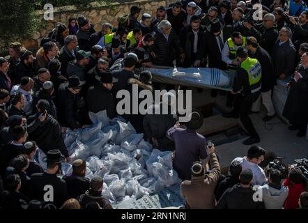 (150113) -- JÉRUSALEM, 13 janvier 2015 -- Un corps victime de l'attaque d'un supermarché parisien est porté sur la tombe lors d'une cérémonie funéraire au cimetière Givat Shaul, à la périphérie de Jérusalem, le 13 janvier 2015. Les dirigeants israéliens et une multitude de personnes en deuil se sont réunis mardi avec les familles de quatre victimes juives de l'attaque terroriste de la semaine dernière contre un supermarché casher de Paris pour une cérémonie funéraire solennelle dans un cimetière de Jérusalem. Yoav Hattab, Yohan Cohen, Philippe Braham et François-Michel Saada, ont été abattus vendredi lors d’une attaque en otage sur le supermarché Hyper Casher dans l’est de Paris. Ils étaient un Banque D'Images