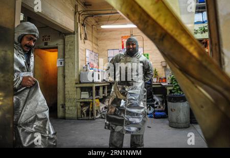BURBANK, le 13 janvier 2015 -- les travailleurs changent de salopette lors d'un événement médiatique pour présenter la production des statuettes en bronze pour la 21e édition annuelle des Screen Actors Guild (SAG) Awards à Burbank, Californie, États-Unis, le 13 janvier 2015. La statuette, connue sous le nom d'acteur , a été conçue à l'origine par Jim Heimann et Jim Barrett, et sculptée par Edward Saenz. Il mesure 16 pouces (40,6 cm) de haut et pèse 12 livres (5,4 kg). Depuis la 1e édition des SAG Awards en 1995, les prix ont été produits par l’American Fine Arts Foundry de Burbank. La 21e cérémonie de remise des prix SAG aura lieu à Los Angeles le 2 janvier Banque D'Images