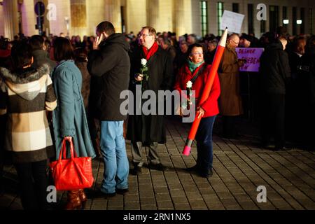 (150113) -- BERLIN, 13 janvier 2015 -- des personnes tenant des fleurs et un modèle de crayon se rassemblent devant la porte de Brandebourg lors d'une veillée rendant hommage aux victimes de l'attaque française Charlie Hebdo et des affrontements armés qui ont suivi à Berlin, en Allemagne, le 13 janvier 2015.) ALLEMAGNE-BERLIN-CHARLIE-HEBDO-ATTACKS-VICTIMS-VIGIL ZhangxFan PUBLICATIONxNOTxINxCHN Berlin Jan 13 2015 célébrités tenant des fleurs et un crayon modèle se rassemblent devant la porte de Brandebourg lors d'une veillée rendant hommage aux victimes de l'attaque française Charlie Hebdo et qui s'ensuivit armée à Berlin Allemagne LE 13 2015 janvier Allemagne Berlin Char de Berlin Banque D'Images