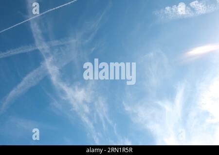 Nuages Cirrus et longue rangée de traînées d'avions. Avion aérien contrail dans fond bleu de ciel nuageux. Ligne horizontale de l'avion rapide volant dans dista Banque D'Images