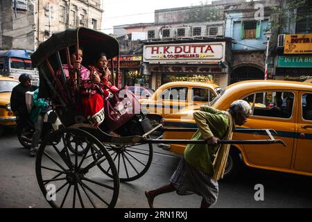 (150119) -- CALCUTTA, 19 janvier 2015 -- des gens prennent le pousse-pousse dans une rue de Calcutta, capitale de l'État indien oriental du Bengale occidental, 19 janvier 2015. En tant que ville métropolitaine en pleine croissance dans un pays en développement, Calcutta est confrontée à une pollution urbaine importante, à la congestion routière, à la pauvreté, à la surpopulation et à d'autres problèmes socio-économiques. INDIA-CALCUTTA-STREET VIEW ZhengxHuansong PUBLICATIONxNOTxINxCHN 150119 Calcutta Jan 19 2015 célébrités prennent le pousse-pousse DANS une rue à Calcutta capitale de l'État indien oriental Bengale OCCIDENTAL Jan 19 2015 comme une ville métropolitaine en croissance dans un pays en développement Calcut Banque D'Images