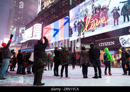 (150126) -- NEW YORK, 26 janvier 2015 -- les gens regardent l'écran dans la neige à Times Square à New York, États-Unis, le 26 janvier 2015. Le gouverneur de l'État de New York, Andrew Cuomo, a déclaré ici lundi un état d'urgence pour New York et ses zones suburbaines alors que la région se prépare à une tempête potentiellement historique qui pourrait déverser jusqu'à 2 pieds de neige. ) US-NEW YORK-WEATHER-BLIZZARD LixChangxiang PUBLICATIONxNOTxINxCHN New York Jan 26 2015 célébrités regarder l'écran dans la neige à Times Square à New York États-Unis Jan 26 2015 New York le gouverneur de l'État de New York Andrew Cuomo a déclaré lundi un État d'EMERGEN Banque D'Images