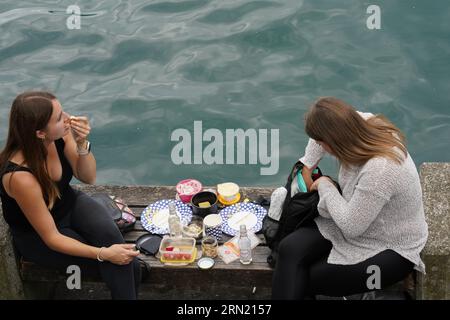 Deux jeunes femmes en train de pique-niquer au bord du lac de Zurich. Banque D'Images