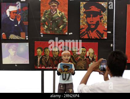 (150213) -- YANGON, Un enfant pose pour une photo devant les portraits du général Aung San lors du centenaire du général Aung San à Yangon, Myanmar, le 13 février 2015. Les trois jours de célébration du centenaire du général Aung San (1915-1947) se dérouleront jusqu'à samedi sur la place du peuple à Yangon, au Myanmar. Le 12 février 1947, toutes les nationalités du Myanmar, dirigées par le général Aung San, ont tenu la conférence historique de Panglong dans l’État Shan et signé l’accord de Panglong, proclamant l’indépendance du pays. Cette journée a été désignée comme la Journée de l Union du Myanmar. ) MYANMAR-YA Banque D'Images