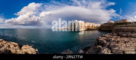 Vue panoramique sur les maisons blanches de la petite ville, située sur une falaise rocheuse et surplombant la côte Adriatique, nuages d'orage au loin. Banque D'Images