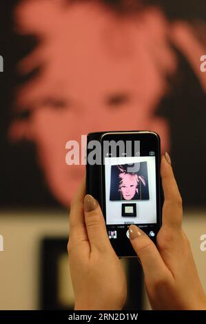 (150228) -- VANCOUVER, le 28 février 2015 -- Un visiteur prend une photo lors de l'inauguration de l'exposition Warhol -- Une idée différente de l'amour dans l'entrepôt de Yaletown à Vancouver, Canada, le 27 février 2015. L'exposition présente 80 estampes et peintures originales provenant de la collection privée d'un homme de Los Angeles et de la Andy Warhol Foundation for Visual Arts Il s agit de la plus grande collection d estampes et de peintures de Warhol au Canada. L'exposition dure jusqu'en mars 30. ) CANADA-VANCOUVER-EXHIBITION-ANDY WARHOL SergeixBachlakov PUBLICATIONxNOTxINxCHN Vancouver février 28 2015 un visiteur prend une photo pendant le O Banque D'Images