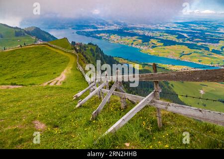Belle vue sur le paysage du sentier de randonnée Kulmweg le long d'une clôture en bois avec fil barbelé sur le sommet du mont Rigi Kulm surplombant le célèbre lac... Banque D'Images