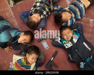 (150318) -- NANNING, 2015 ans -- des enfants écoutent de la musique sur la scène d'un gala de célébration du festival du printemps dans le village de Nongding, dans le comté de Bansheng, dans la région autonome de Guangxi Zhuang, dans le sud de la Chine, le 17 février 2015. Les villages de Nongding et Nongchao sont situés dans le comté de Bansheng, une zone rurale de topographie karstique inhabitable dans le Guangxi, selon la conclusion de certains responsables de l’Organisation des Nations Unies pour l’alimentation et l’agriculture (FAO). Les résidents locaux, dont la plupart appartiennent au groupe ethnique Yao, ont une tradition frustrante avec des costumes festifs colorés, tambour de bronze et performance de danse. Cependant, ce tra Banque D'Images