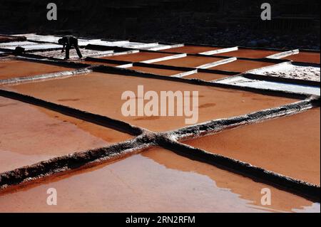 Un villageois travaille sur des marais salants dans le comté de Markam, dans la région autonome du Tibet du sud-ouest de la Chine, le 21 mars 2015. Le comté de Markam, avec de riches ressources en sel, a plus de 3 000 casseroles de sel pour évaporer la saumure au soleil avec une technique ancestrale depuis la dynastie Tang (618-907AD), qui est également la plus ancienne méthode de production de sel. Cette méthode d évaporation du sel a été classée comme l un des biens culturels immatériels nationaux de la Chine en 2009. (Wyo) CHINE-TIBET-MARKAM-PRODUCTION DE SEL-MÉTHODE LA PLUS ANCIENNE (CN) ZhangxXiaohua PUBLICATIONxNOTxINxCHN un village travaille SUR des marais salants dans le comté de Markam Sud-Ouest Chine Sud Tibet Auto Banque D'Images