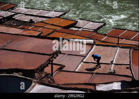 Un villageois travaille sur des marais salants dans le comté de Markam, dans la région autonome du Tibet du sud-ouest de la Chine, le 21 mars 2015. Le comté de Markam, avec de riches ressources en sel, a plus de 3 000 casseroles de sel pour évaporer la saumure au soleil avec une technique ancestrale depuis la dynastie Tang (618-907AD), qui est également la plus ancienne méthode de production de sel. Cette méthode d évaporation du sel a été classée comme l un des biens culturels immatériels nationaux de la Chine en 2009. (Wyo) CHINE-TIBET-MARKAM-PRODUCTION DE SEL-MÉTHODE LA PLUS ANCIENNE (CN) WenxTao PUBLICATIONxNOTxINxCHN un village travaille SUR des marais salants dans le comté de Markam Sud-Ouest Chine Sud Tibet autonome Banque D'Images