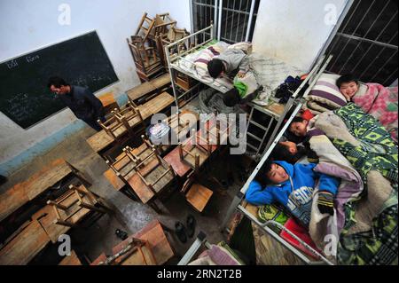 (150323) -- BANSHENG, 23 mars 2015 -- des élèves allongés sur des lits dans une salle de classe de l'école primaire de Nongyong dans le comté de Bansheng, dans la région autonome de Guangxi Zhuang, dans le sud de la Chine, 18 décembre 2013. L'école primaire de Nongyong a été construite en 1964. Il est situé dans le comté de Bansheng, une zone rurale de topographie karstique dans le Guangxi. Son bâtiment scolaire initial se compose de 12 maisons d'un étage. Dans les années 1990, un bâtiment d'enseignement de deux étages et un dortoir rugueux ont été construits. Il y a environ 250 étudiants des 22 villages de Nongyong. Tous les lundis, la plupart d'entre eux doivent marcher sur des collines pour se rendre à l'école. En semaine, ab Banque D'Images