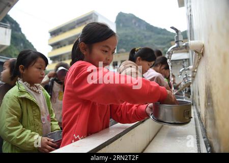 (150323) -- BANSHENG, 23 mars 2015 -- des élèves lavent la vaisselle après le déjeuner à l'école primaire de Nongyong dans le comté de Bansheng, dans la région autonome de Guangxi Zhuang du sud de la Chine, 12 novembre 2014. L'école primaire de Nongyong a été construite en 1964. Il est situé dans le comté de Bansheng, une zone rurale de topographie karstique dans le Guangxi. Son bâtiment scolaire initial se compose de 12 maisons d'un étage. Dans les années 1990, un bâtiment d'enseignement de deux étages et un dortoir rugueux ont été construits. Il y a environ 250 étudiants des 22 villages de Nongyong. Tous les lundis, la plupart d'entre eux doivent marcher sur des collines pour se rendre à l'école. En semaine, environ Banque D'Images