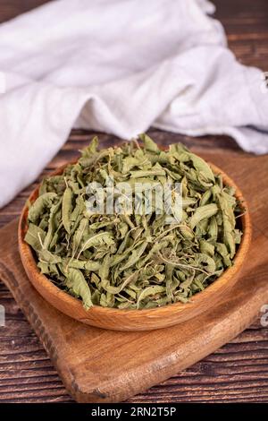 Thé au baume séché. Feuilles de thé à la mélisse séchées au soleil dans un bol en bois. phytothérapie. Gros plan Banque D'Images