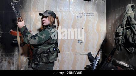 Une femme sniper prend position dans un buliding dans la banlieue de Daraya de la capitale Damas, en Syrie, le 5 avril 2015. Les snipers sont membres de la force féminine de la Garde républicaine syrienne. Leur unité se compose d'environ 800 combattantes volontaires, célibataires, âgées de 20 à 24 ans. Leur tâche est de travailler aux côtés de l'armée syrienne dans sa bataille contre les rebelles. (jl) SYRIA-DAMAS-FEMMES SNIPERS ZhangxNaijie PUBLICATIONxNOTxINxCHN une femme SNIPER prend dans une buliding dans la banlieue de la capitale Damas Syrie LE 5 2015 avril, les snipers sont membres de la Force féminine de Repu syrien Banque D'Images