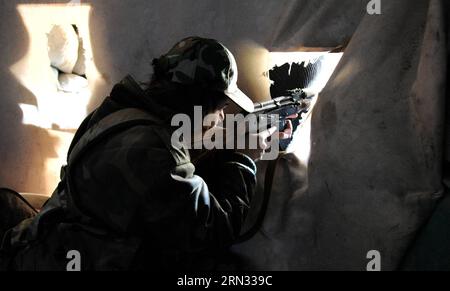 Une femme sniper prend position dans un buliding dans la banlieue de Daraya de la capitale Damas, en Syrie, le 5 avril 2015. Les snipers sont membres de la force féminine de la Garde républicaine syrienne. Leur unité se compose d'environ 800 combattantes volontaires, célibataires, âgées de 20 à 24 ans. Leur tâche est de travailler aux côtés de l'armée syrienne dans sa bataille contre les rebelles. (jl) SYRIA-DAMAS-FEMMES SNIPERS ZhangxNaijie PUBLICATIONxNOTxINxCHN une femme SNIPER prend position dans un buliding dans la banlieue DARAYA de la capitale Damas Syrie LE 5 2015 avril, les snipers sont membres de la Force féminine i. Banque D'Images