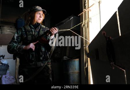 Une femme sniper prend position dans un buliding dans la banlieue de Daraya de la capitale Damas, en Syrie, le 5 avril 2015. Les snipers sont membres de la force féminine de la Garde républicaine syrienne. Leur unité se compose d'environ 800 combattantes volontaires, célibataires, âgées de 20 à 24 ans. Leur tâche est de travailler aux côtés de l'armée syrienne dans sa bataille contre les rebelles. (jl) SYRIA-DAMAS-FEMMES SNIPERS ZhangxNaijie PUBLICATIONxNOTxINxCHN une femme SNIPER prend dans une buliding dans la banlieue de la capitale Damas Syrie LE 5 2015 avril, les snipers sont membres de la Force féminine de Repu syrien Banque D'Images