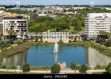 France, Hérault, Montpellier, quartier Port Marianne, immeubles autour du bassin Jacques coeur et du Parc Georges Charpak en arrière-plan Banque D'Images